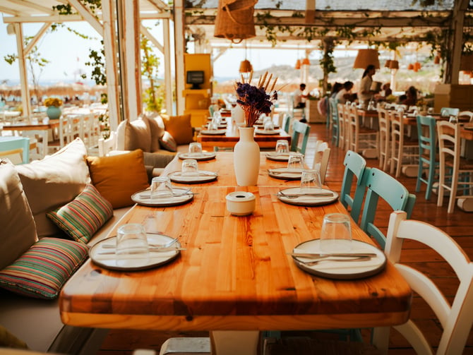 Bright open-air beachfront restaurant with wood tables and ocean views